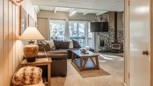 Ein gemütliches Wohnzimmer mit Sofa, Couchtisch und Kamin.