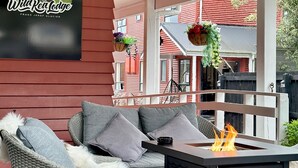 A covered outdoor seating area with wicker chairs and a fire feature. - Wild Kea Lodge Franz Josef (Franz Josef Glacier)