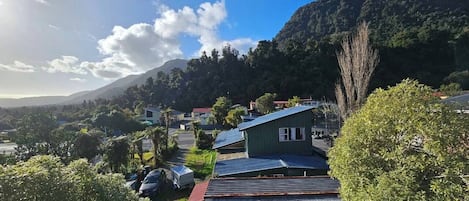 A residential area with houses, a mountain in the background, and a clear sky.