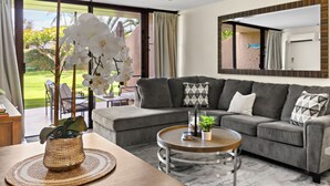 Un salon moderne avec un canapé gris, une table basse et une orchidée en pot.