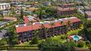 Un hôtel à plusieurs étages, doté d’une piscine et de panneaux solaires sur le toit.