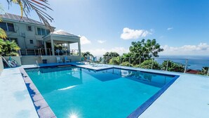 A rectangular swimming pool with a clear blue edge, surrounded by a light-colored deck.