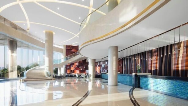 Un vestíbulo amplio con una escalera curva, una zona de recepción y un diseño de techo moderno.