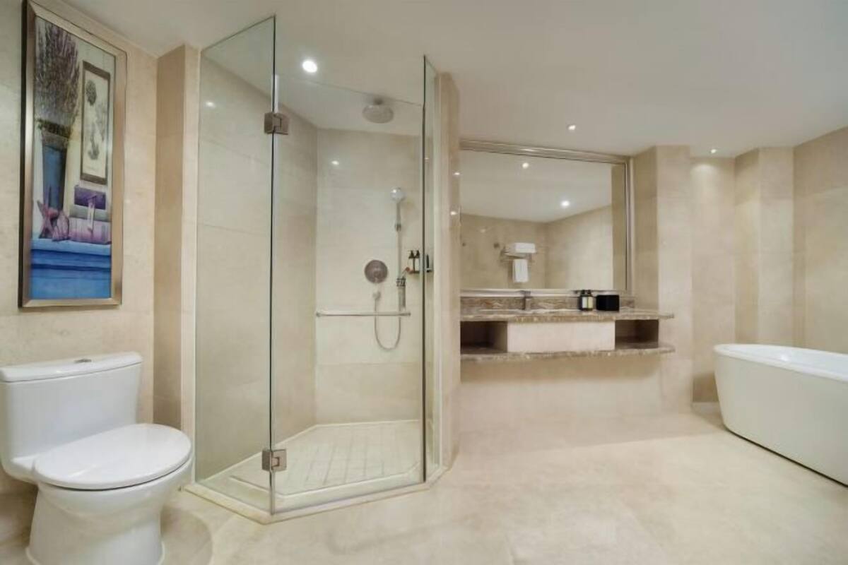 Un baño moderno con ducha de vidrio, inodoro blanco y bañera.