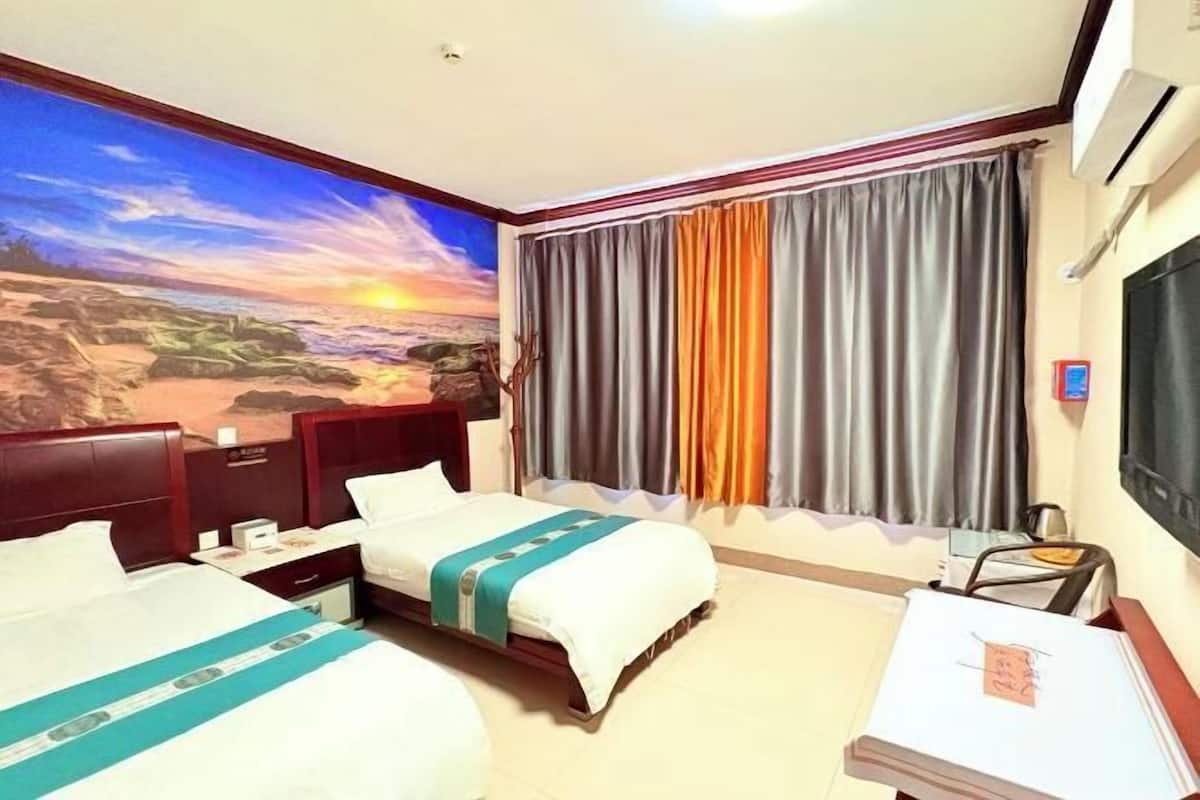 A hotel room with two beds, a large mural of a sunset, and a TV on the wall.