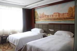 A hotel room with two beds, a painting of a cityscape, a small table, and a chair. - Vienna Hotel (Guiyang Fountain Subway Station Yangmingci Subway Station) (Guiyang)