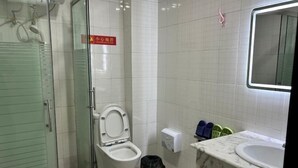 Un baño con inodoro, lavabo y cabina de ducha de vidrio.
