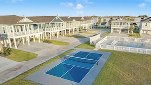 Un quartier résidentiel avec des maisons, un court de tennis et une piscine.
