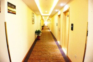 A hotel corridor with doors on both sides, a carpeted floor, and a sign indicating room number 8357.
