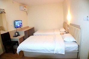 Una habitación de hotel con una cama, un escritorio con una computadora y una silla.