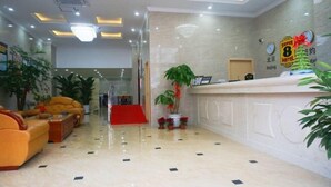A hotel lobby with a reception desk, a red carpet, and a seating area with sofas. - Super 8 Shanghai Dongjing Huanlegu Dongye Road (Shanghai)