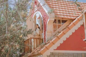Ein Gebäude mit roter Fassade und einem Balkon mit Geländer.