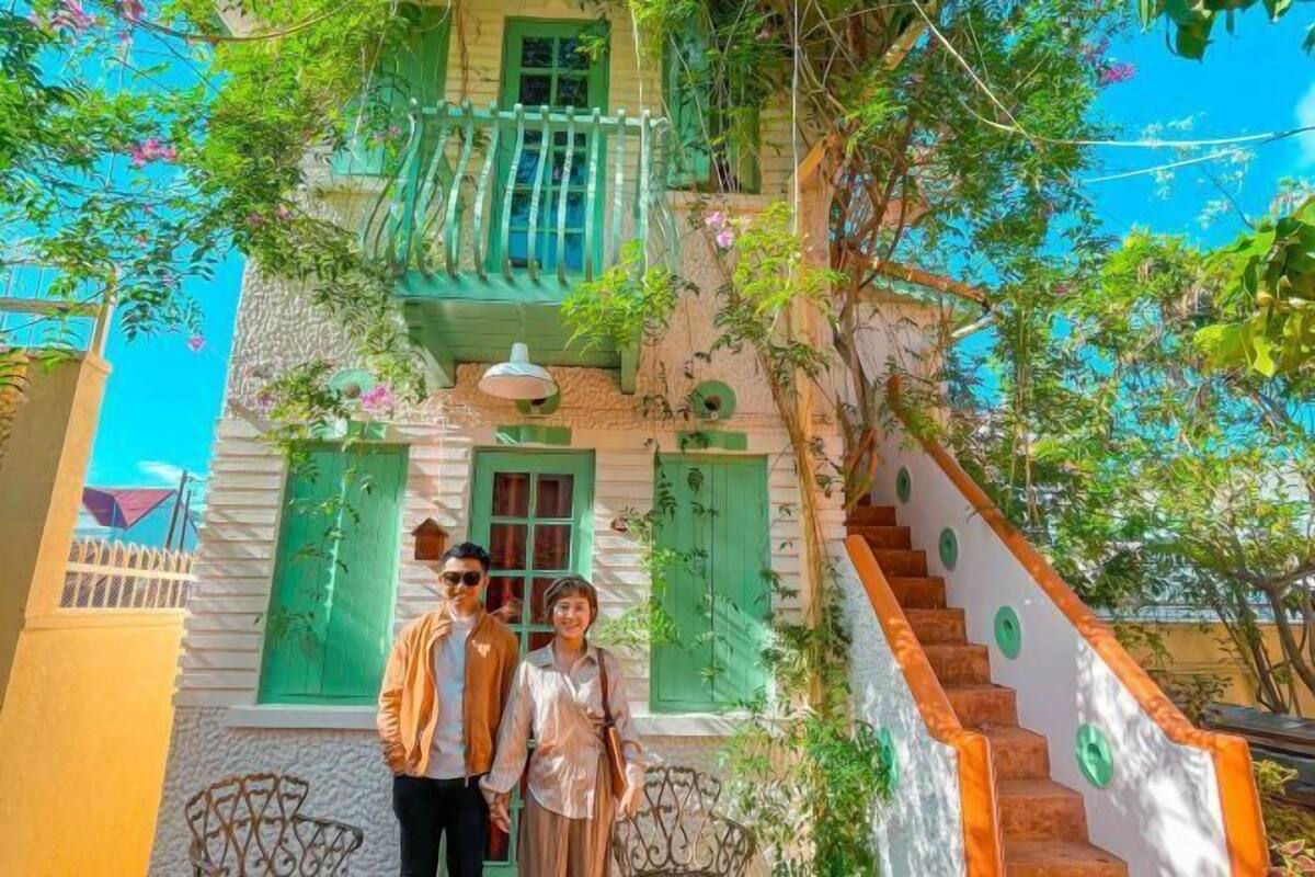 Un edificio con una escalera, un balcón y una ventana con persiana.
