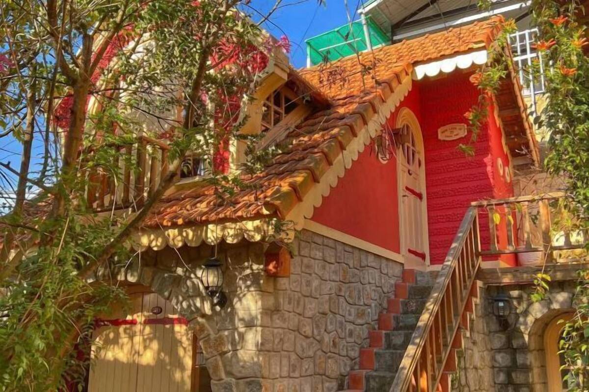 Un edificio con fachada roja, escalones de piedra y un pequeño balcón.