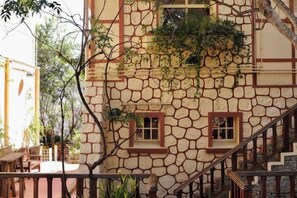 Un bâtiment en pierre avec un escalier et une petite fenêtre.