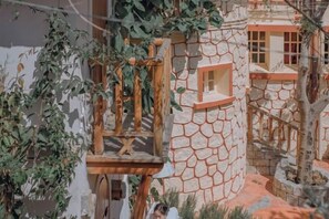 Une maquette d’un bâtiment en pierre, avec une chaise en bois et une fenêtre.