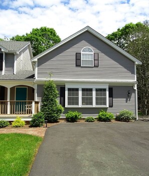 A two-story house with a front porch, a covered entryway, and a driveway.