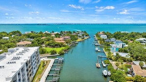 A marina with boats docked, a waterway, and residential buildings with balconies. - Resort Pool & Spa, Fitness Center, Pet Friendly, Waterfront Condo in Downtown! (Sarasota)
