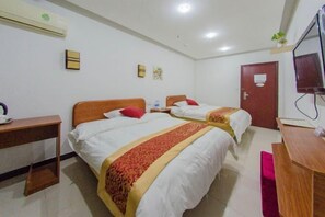 Une chambre d’hôtel avec deux lits, un bureau, une chaise, une télévision et un appareil de climatisation.