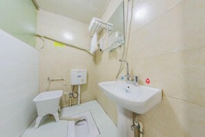 Une petite salle de bain comprenant des toilettes, un bidet et un lavabo.
