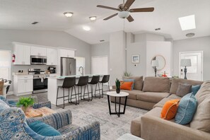 A modern living space with a kitchen, dining area, and seating area. - Disney-Area 4BR | Pool + Patio (Kissimmee)