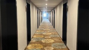 A long, narrow hallway with a patterned carpet and doors on both sides. - Ketai Boutique Hotel (Shaoxing Keqiao Oriental Landscape Park) (Shaoxing)