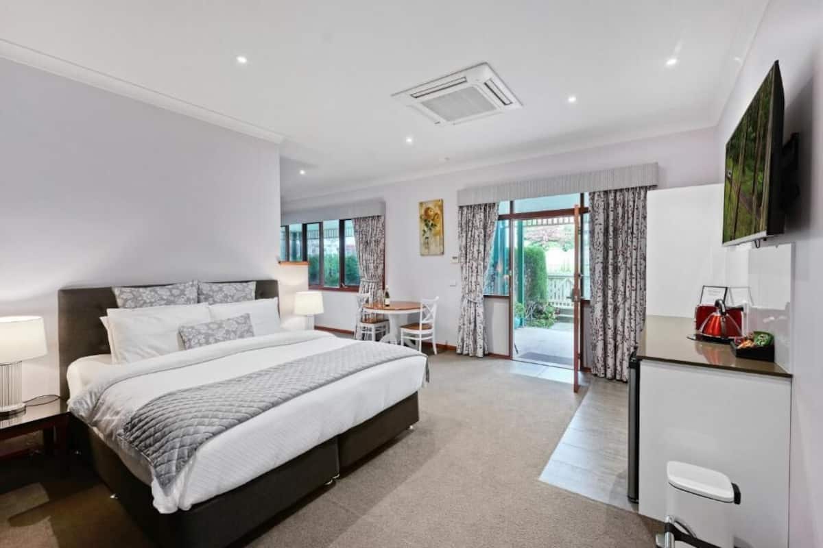 Een moderne hotelkamer met een groot bed, een bureau, een stoel en een televisie aan de muur.