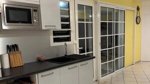 Eine Küche mit Mikrowelle, Spüle und Schränken.