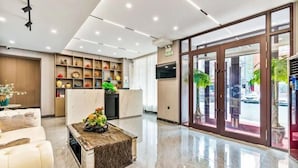 A modern lobby with a reception desk, a seating area with a coffee table, and a large glass door leading outside. - Homeinn Ease Hotel (Harbin Central Avenue Flood Control Memorial Tower) (Harbin)