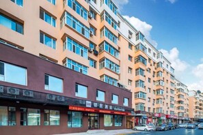 A multi-story building with a row of shops on the ground floor. - Homeinn Ease Hotel (Harbin Central Avenue Flood Control Memorial Tower) (Harbin)