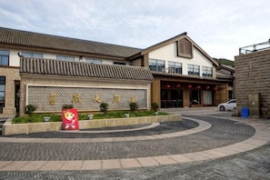 A hotel with a traditional architectural style, a courtyard, and a sign with Chinese characters. - Cihang Hotel (Zhoushan)