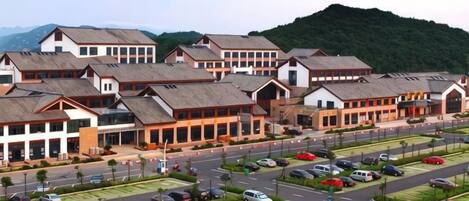 A hotel with multiple buildings, a parking lot, and a road.