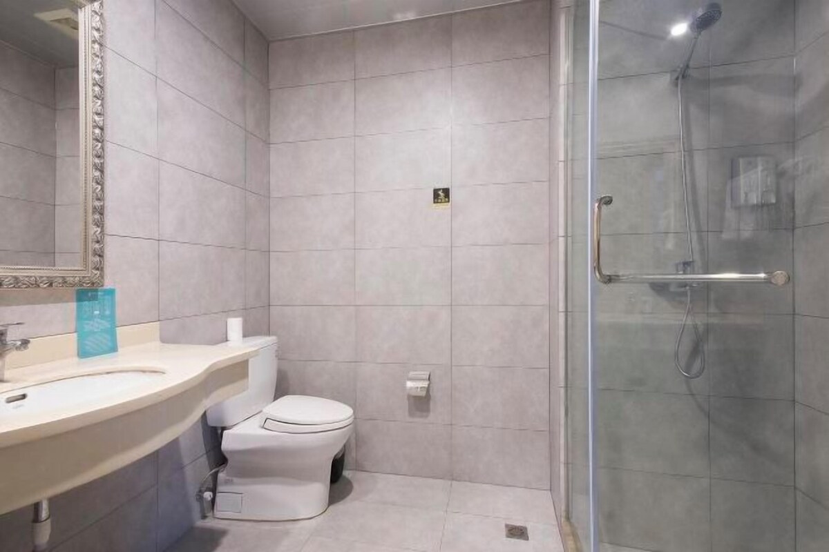 A bathroom with a toilet, sink, and shower area.