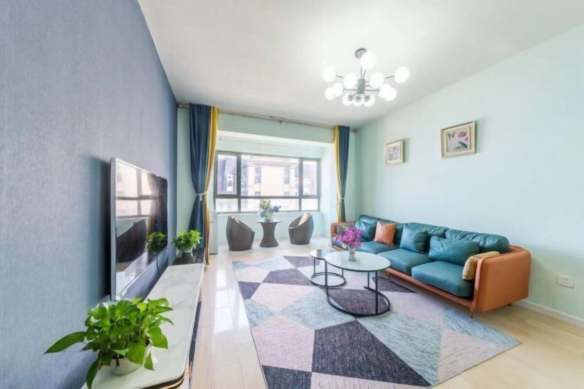 A living room with a sofa, coffee table, and a large window.