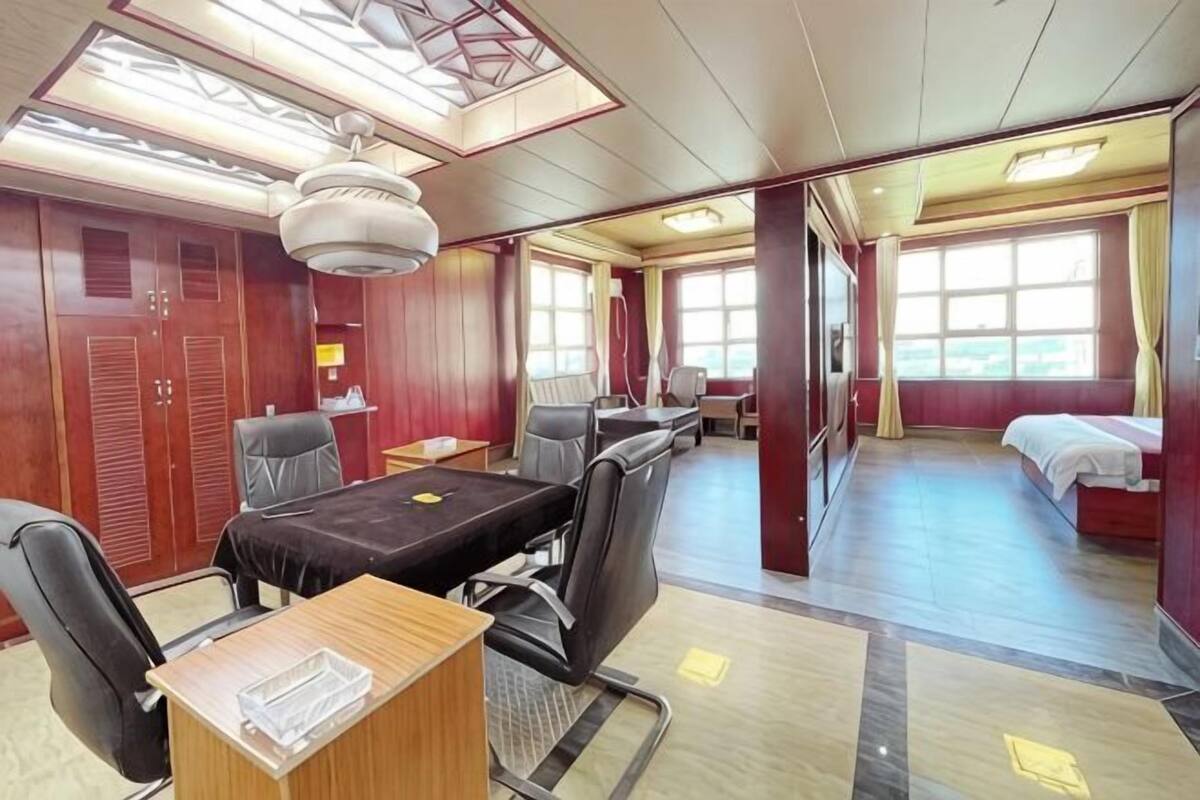 A train car with a dining area, a bed, and a large window.