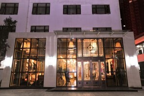 A building with large glass windows, a central entrance, and a modern design. - Wujia Yizhan Boutique Inn (Zhengzhou)