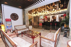 A lobby with seating, a reception desk, and a chandelier. - Wujia Yizhan Boutique Inn (Zhengzhou)