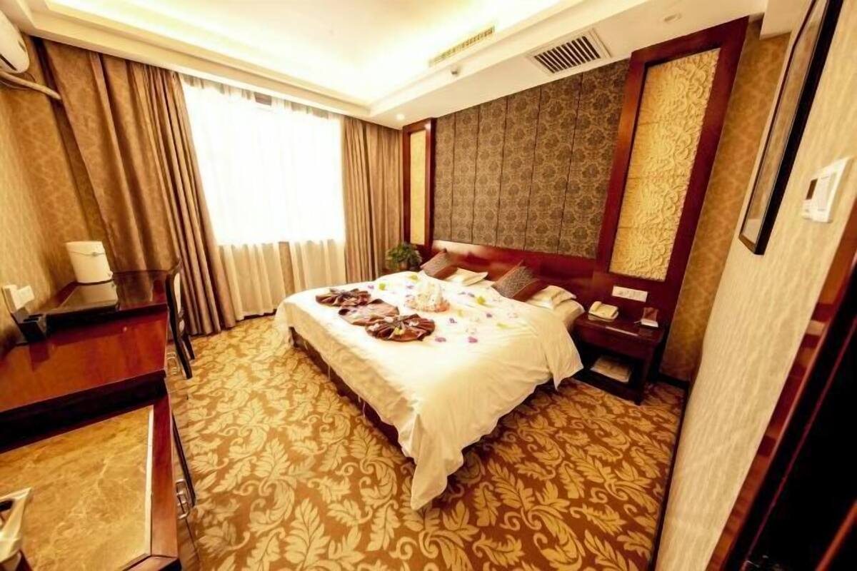 Una habitación de hotel con una cama grande, un escritorio y un teléfono.
