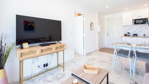 Una sala de estar moderna con televisor de pantalla plana, mueble de entretenimiento de madera y una mesa de centro.
