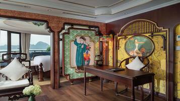 A traditional room with a bed, a desk, and a view of the sea.