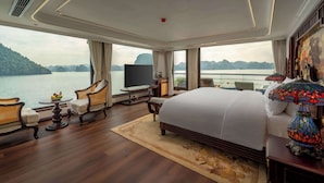 A spacious bedroom with a large bed, a TV, and a view of a lake. - L'amour Cruise (Tuan Chau)