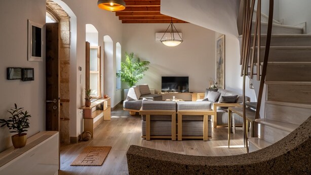 A spacious living room with a fireplace, a sofa set, and a TV.