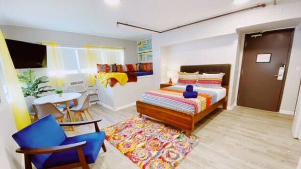 A modern hotel room with a bed, a desk, and a chair. - Accessible South Beach Unit w/ Free Perks (Miami Beach)