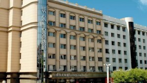 A hotel with a modern facade, featuring a series of balconies and a prominent vertical sign. - Wolff Hotel (Suifenhe)