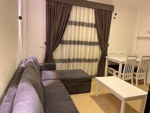 Una sala de estar con un sofá, una mesa y sillas.