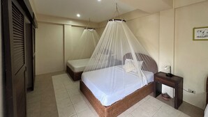 A bedroom with a canopy bed, a bedside table, and a small wooden nightstand. - Lubi Resort (Santander)