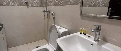 Un baño con inodoro, bidé y lavamanos.