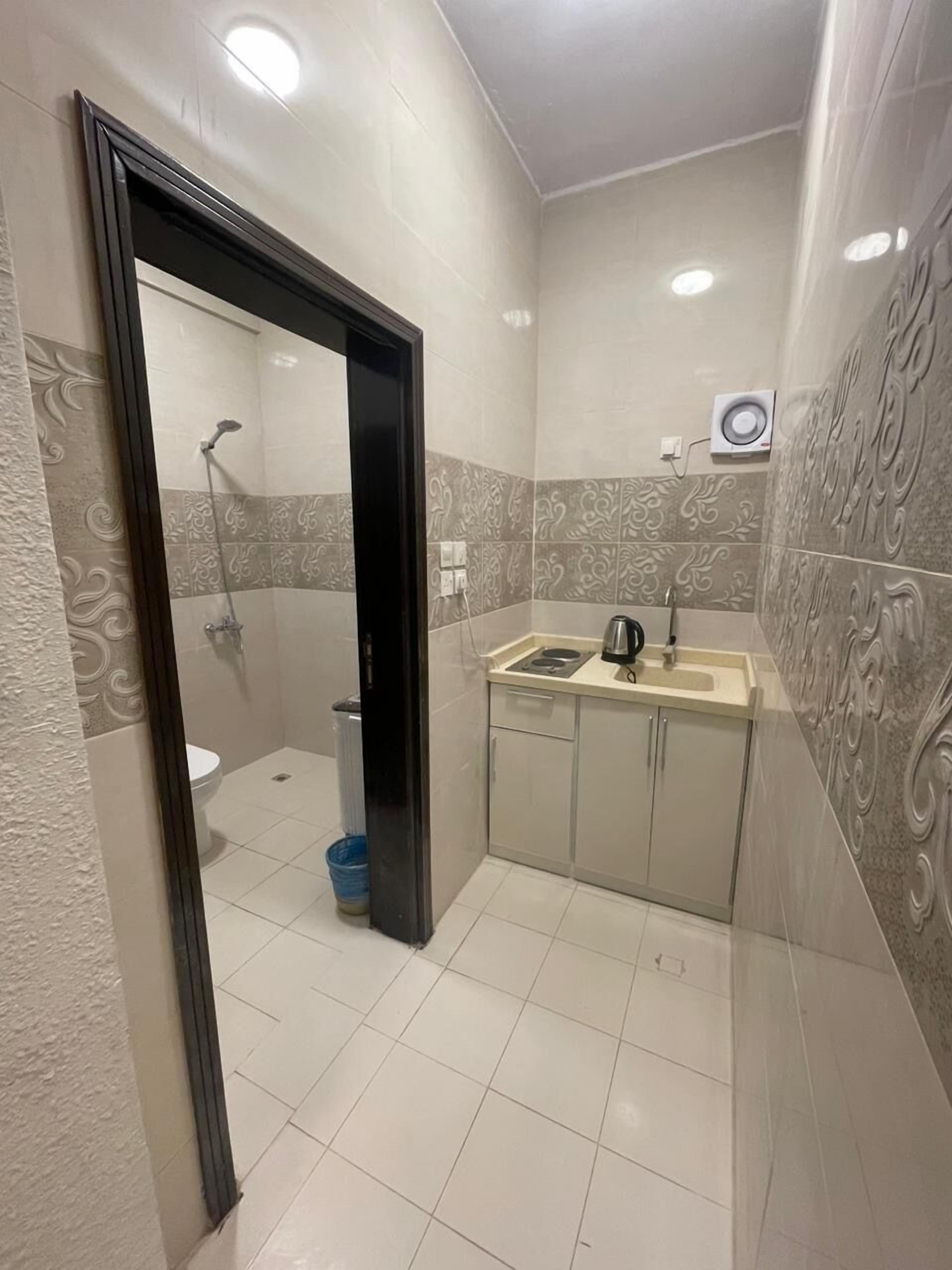 A compact bathroom with a shower, toilet, and sink.