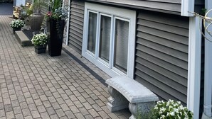 Une maison à deux étages avec un chemin en briques menant à l’entrée.