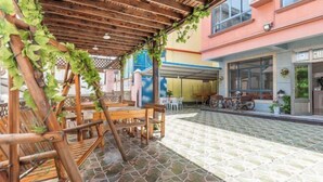An outdoor patio with wooden furniture and a tiled floor. - Shengsi Yajing Homestay (Shengsi)